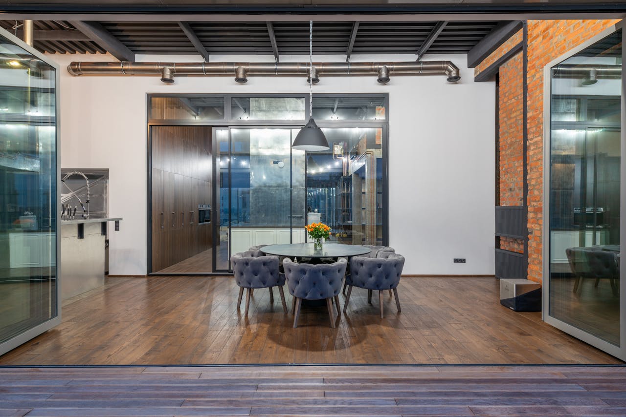 about-01 Interior of spacious dining room with round table and comfortable soft chairs placed in modern apartment